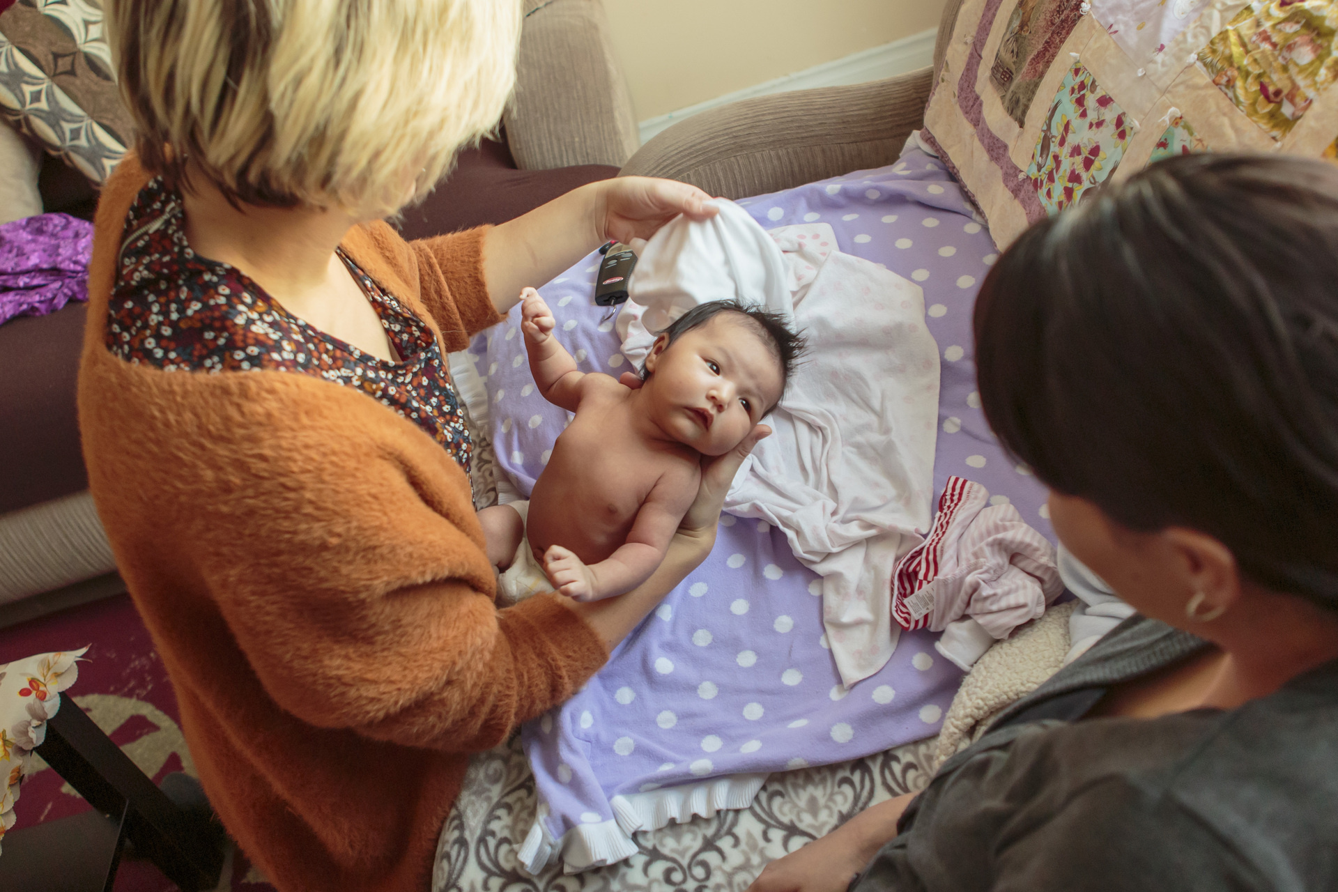 Six weeks old baby with her mother, while checking by a midwife.